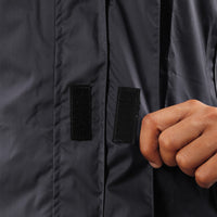 Velcro-secured storm flap on the black STRATUS rainwear jacket for added weather protection.