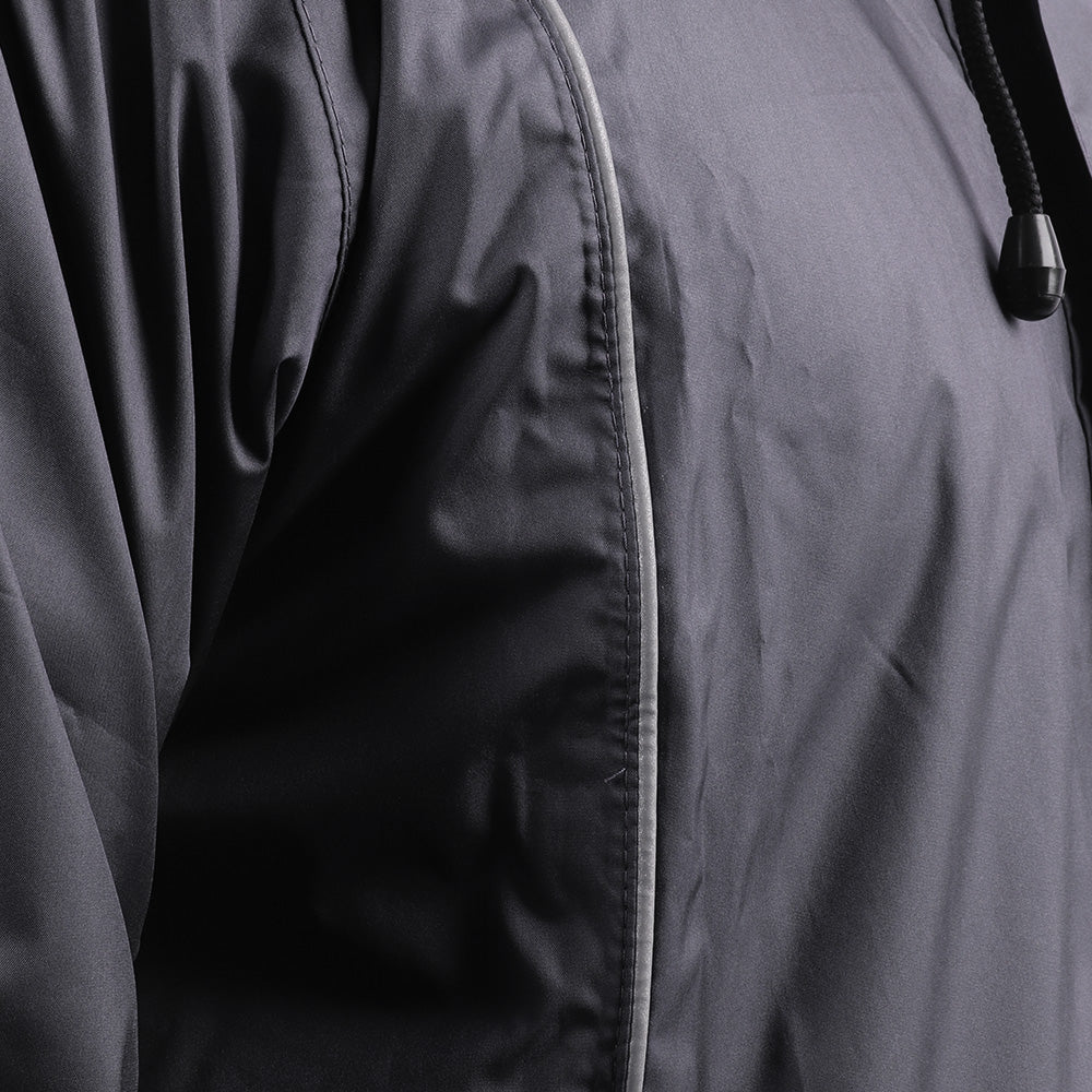 Close-up of the silver piping detail on the black STRATUS rainwear suit.