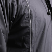 Close-up of the silver piping detail on the black STRATUS rainwear suit.
