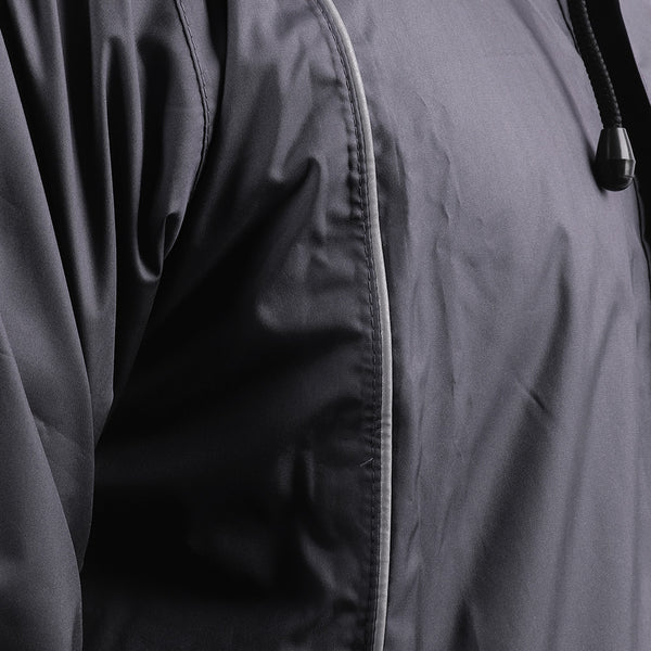 Close-up of the silver piping detail on the black STRATUS rainwear suit.