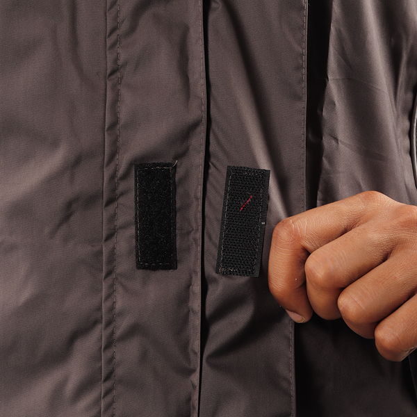 Velcro-secured storm flap on the grey STRATUS rainwear jacket for added weather protection.